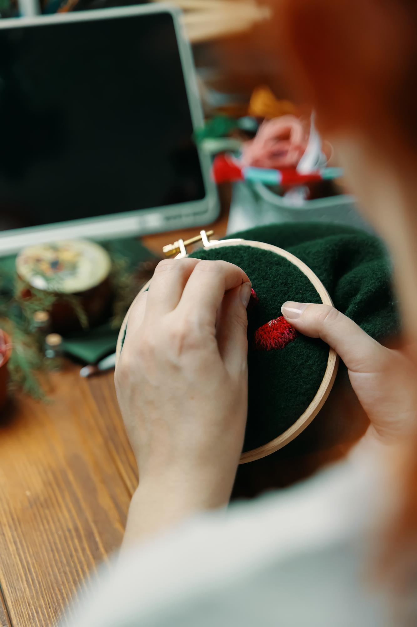 Artisan at work stitching gold thread